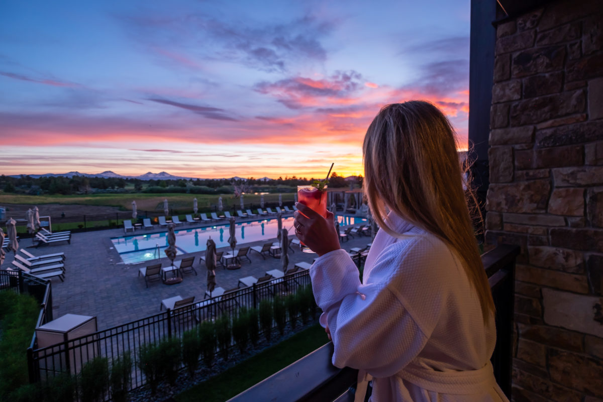 Sunset View from the Huntington Lodge balcony overlooking the view of the pool and Cascades at Pronghorn Resort in Bend Oregon