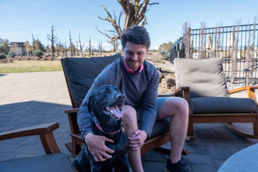 Guest sitting on a patio with their dog at Juniper Preserve